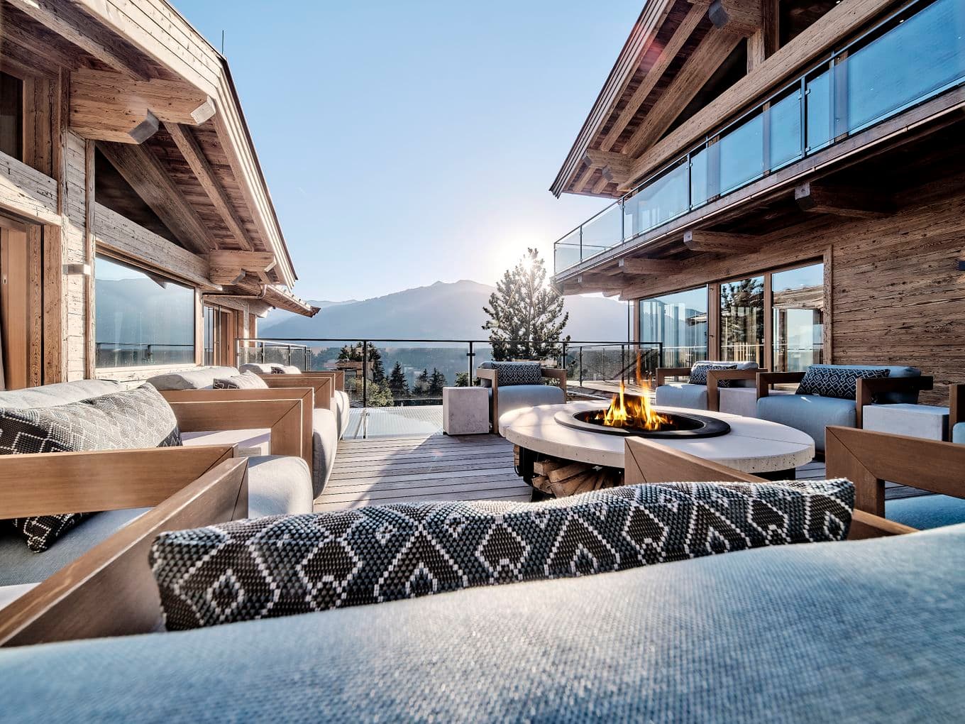 Chalet-Terrasse mit gemütlichen Sitzmöglichkeiten, Feuerstelle und Bergblick.