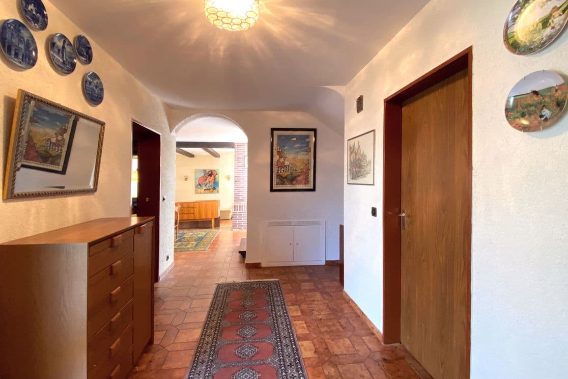 Hallway with built-in cabinet, decorative plates and typical 1970s tile flooring