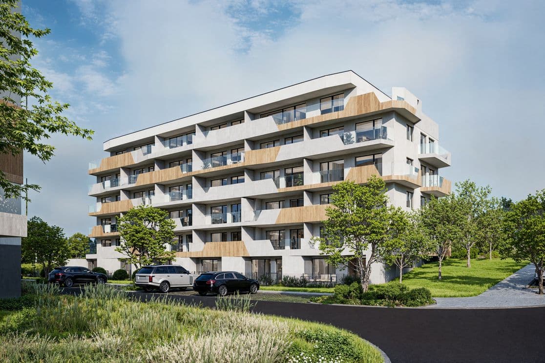 Modern residential building Terasy Sylván in Pilsen, five floors with balconies and terraces, surrounded by greenery and parked cars on the street in front.