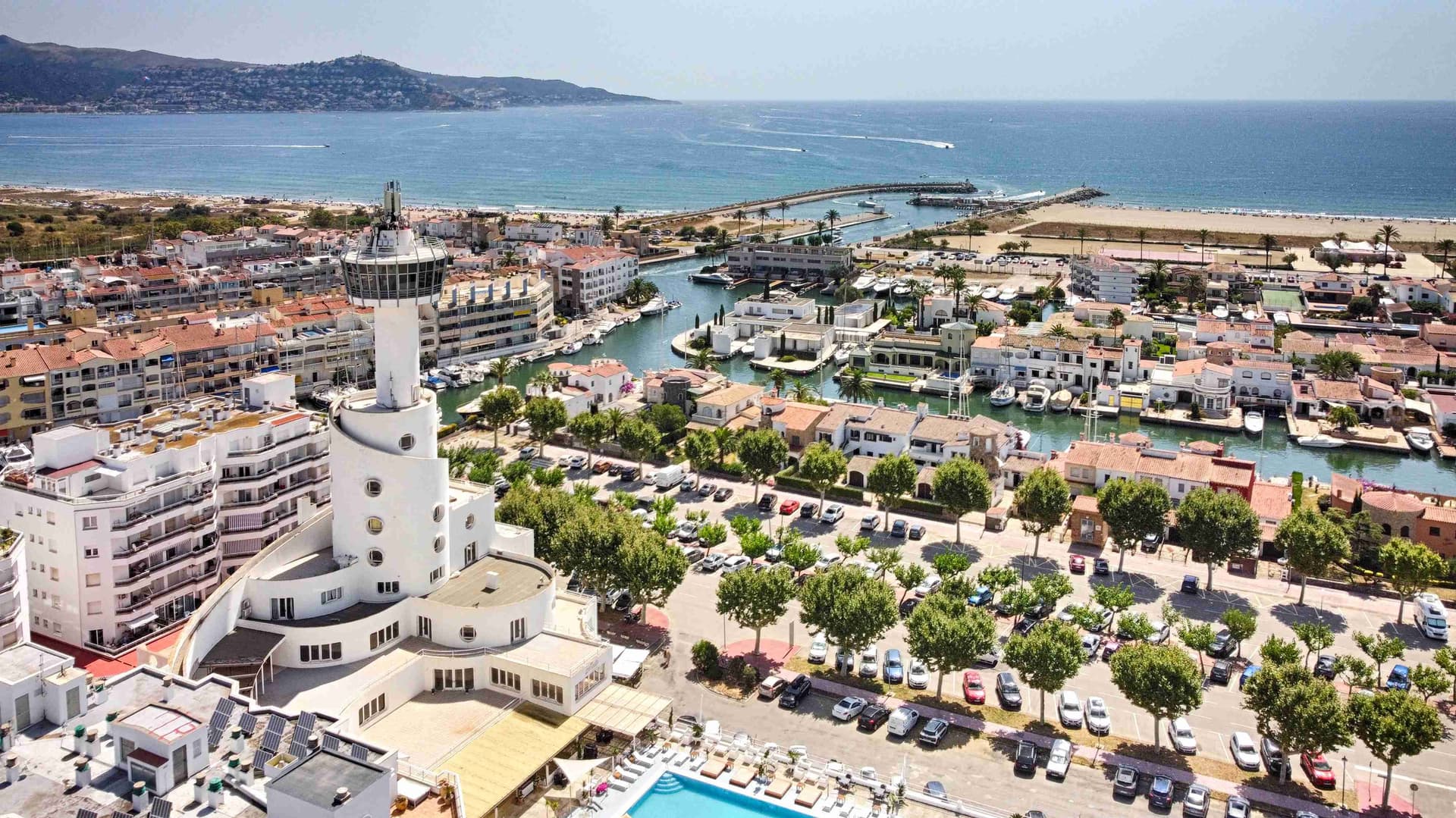 Vista aèria del mar des del centre de la ciutat d'Empuriabrava, els seus canals i vaixells, i la piscina pública.