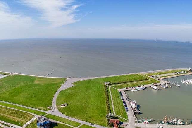 Aerial view of Norddeich on the North Sea coast, harbor with boats visible.