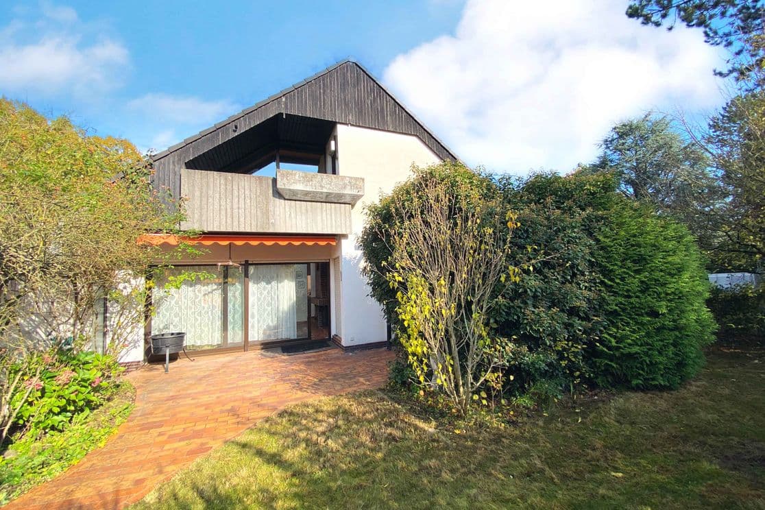 Exterior view of the 1978 house before renovation showing terrace and garden