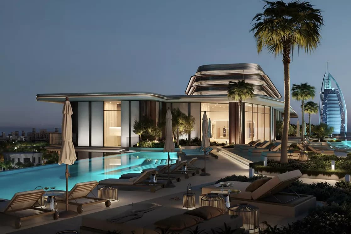 Luxurious rooftop terrace at dusk with a pool, sun loungers, palm trees, and city views, including a distinctive sail-shaped building.