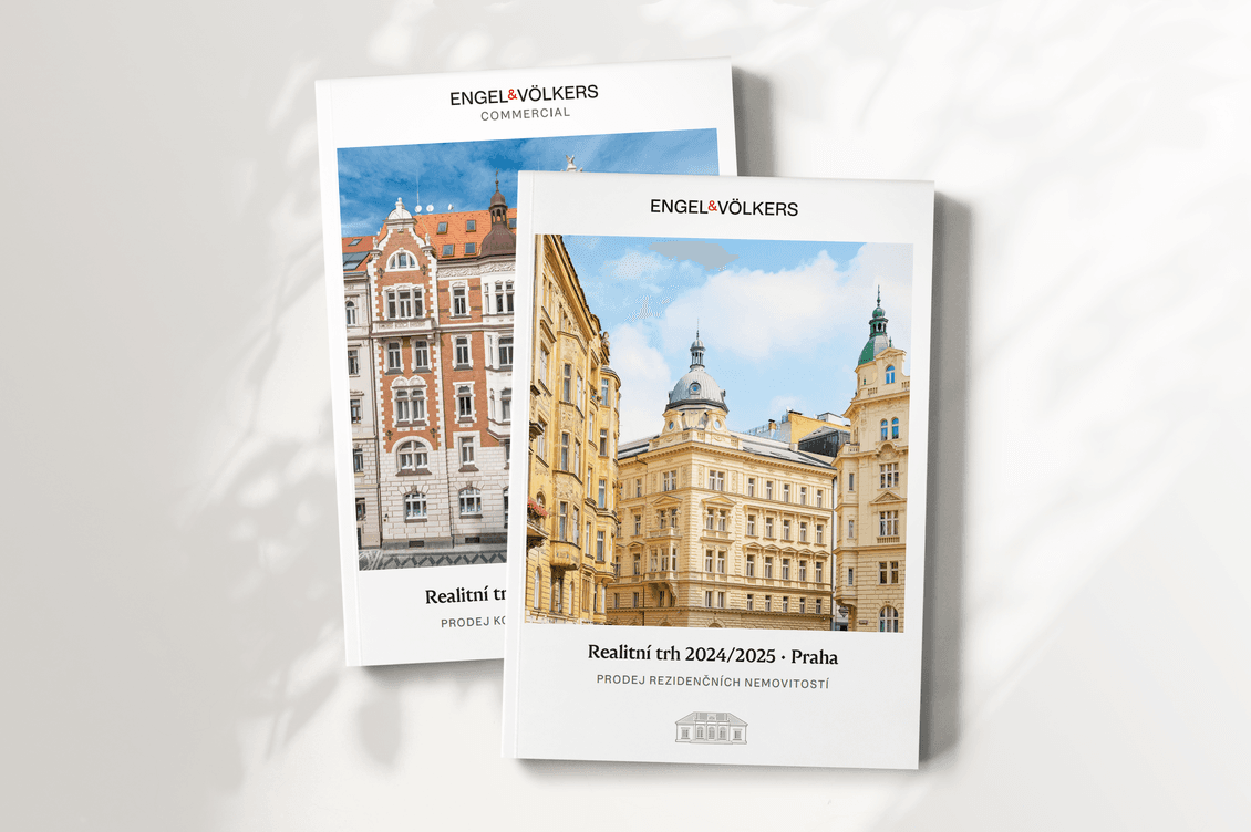Dvě brožury Engel & Völkers položené na bílém podkladu. Přední obálka zobrazuje rezidenční zprávu s fotografií historických budov v centru Prahy pod modrou oblohou. Druhá, částečně zakrytá, představuje komerční zprávu s jinou pražskou architekturou.