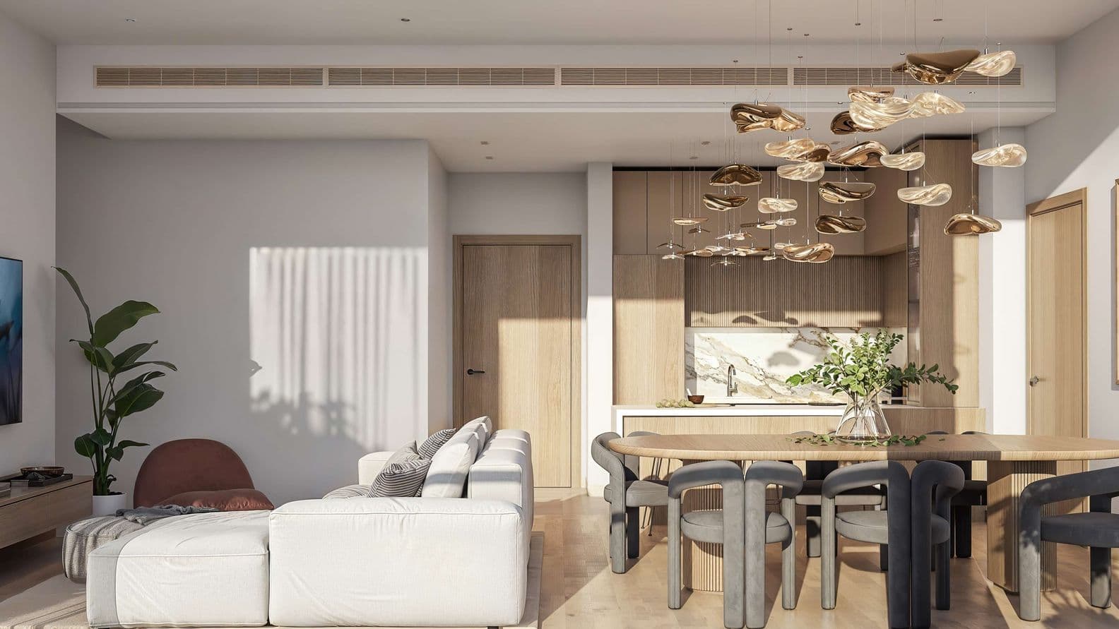 View from kitchen into the living and dining space of a Taiyo Residences apartment, highlighting natural wood accents, designer light fixtures, and a cozy, modern layout.