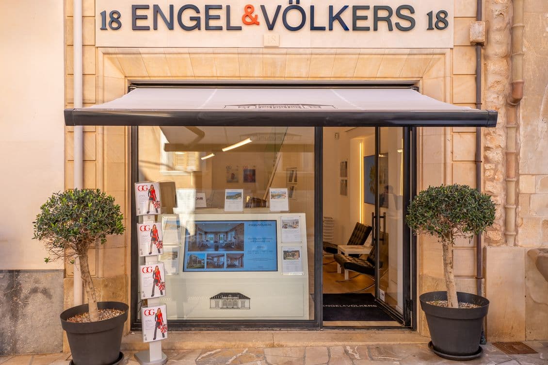 Exterior view of the main entrance to the Engel & Völkers property shop in Santanyí, featuring traditional architecture with a clean, inviting design