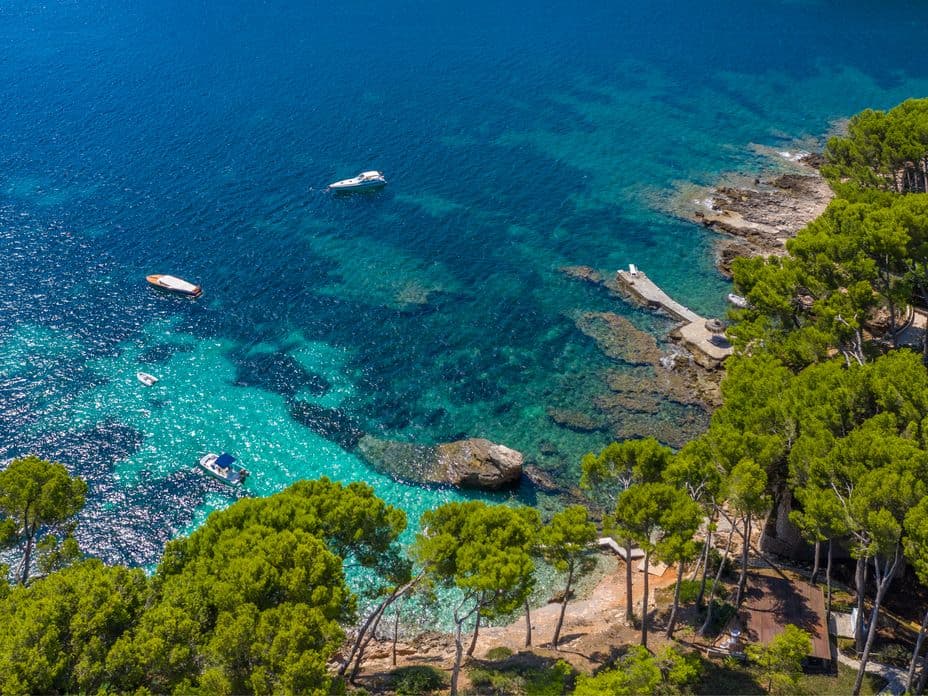 Scenic view of Formentor beach, with crystal-clear waters and surrounding lush greenery in northern Mallorca