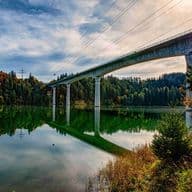 Lechtal Bridge in Schongau, Bavaria – modern concrete structure spanning a lake with forested hills in autumn colors