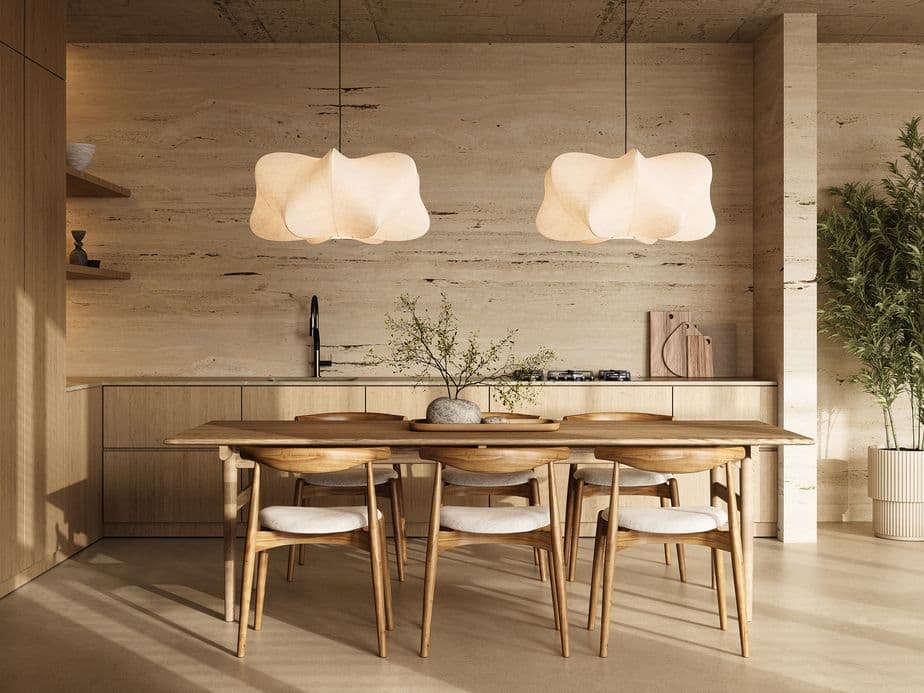 An elegantly arranged kitchen dining space featuring unique pendant lighting and a wooden dining set in a contemporary interior