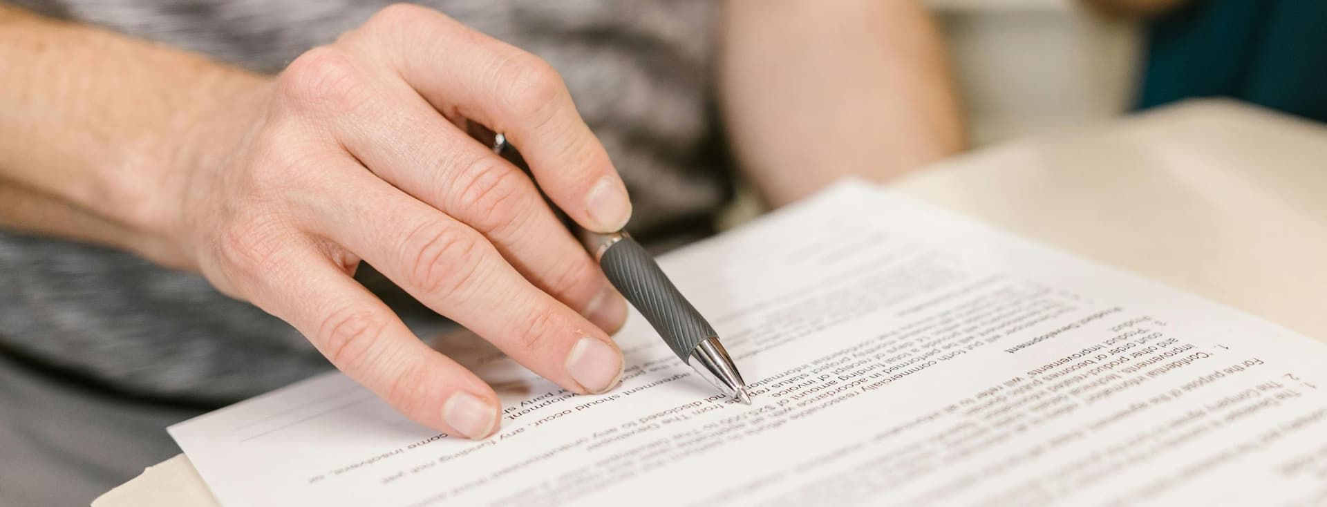 The tenant checks the contents of a contract by running a ballpoint pen over the individual lines.