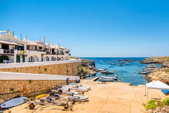 Vista panorámica del pintoresco pueblo de Binibeca en Menorca, con sus estrechas calles encaladas y su arquitectura mediterránea clásica.