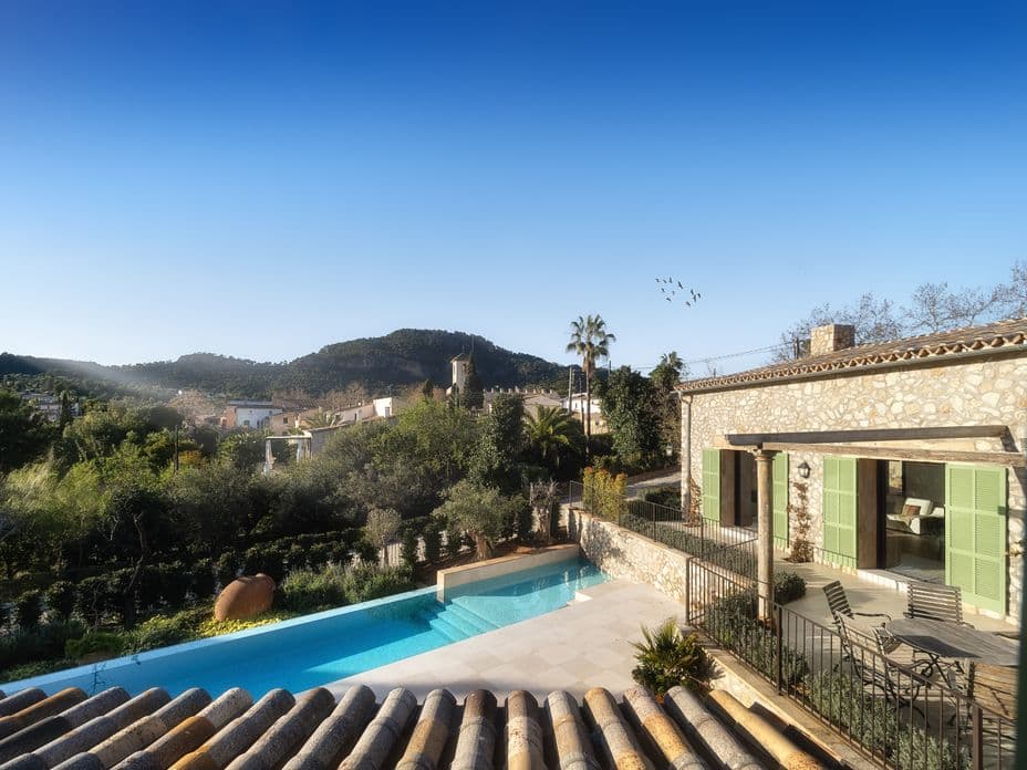 Moderne Finca in Es Capdellà, mit zeitgenössischem architektonischen Design, großen Fenstern und einem großzügigen Außenbereich, umgeben von üppigem Grün.