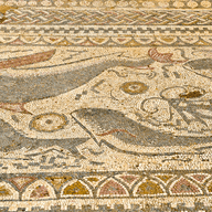 Antikes Mosaik mit Darstellungen von Walen und Meereslebewesen, mit komplizierten geometrischen Mustern und Rändern in erdigen Farbtönen.