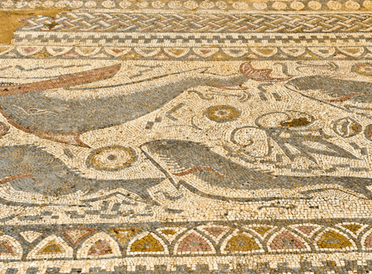 Antikes Mosaik mit Darstellungen von Walen und Meereslebewesen, mit komplizierten geometrischen Mustern und Rändern in erdigen Farbtönen.