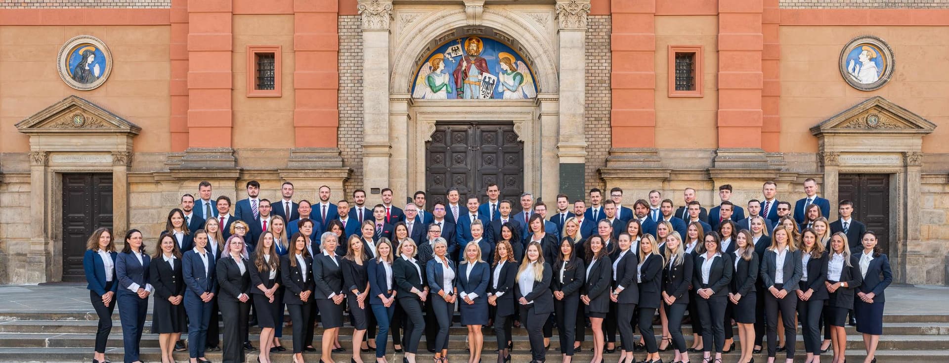 Skupinová fotografie kolegů z Engel & Völkers pořízená v kanceláři. Profesionální, a zároveň přátelská atmosféra odráží týmového ducha a spolupráci v realitním prostředí.