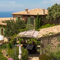 A mediterranean villa with a pool and sea view.