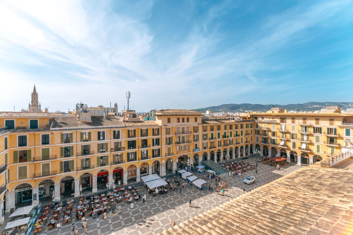 Drone shot capturing the lively Plaza Mayor in Palma, surrounded by traditional buildings and narrow streets in the heart of the Old Town