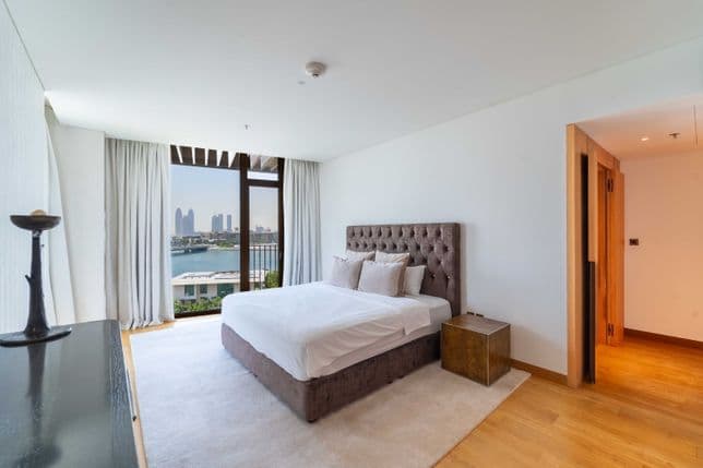 Geräumiges Schlafzimmer in neutralen Farbtönen mit Blick auf die Skyline von Dubai.