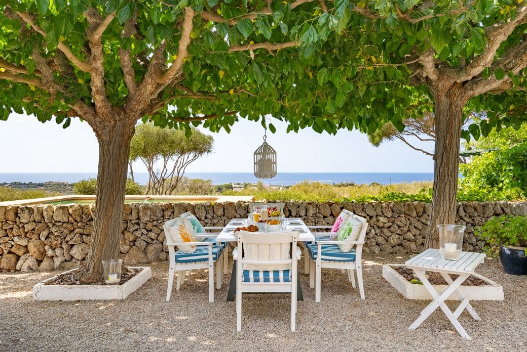 Encantadora finca menorquina con una hermosa terraza y vistas panorámicas al mar, el lugar ideal para relajarse al aire libre.
