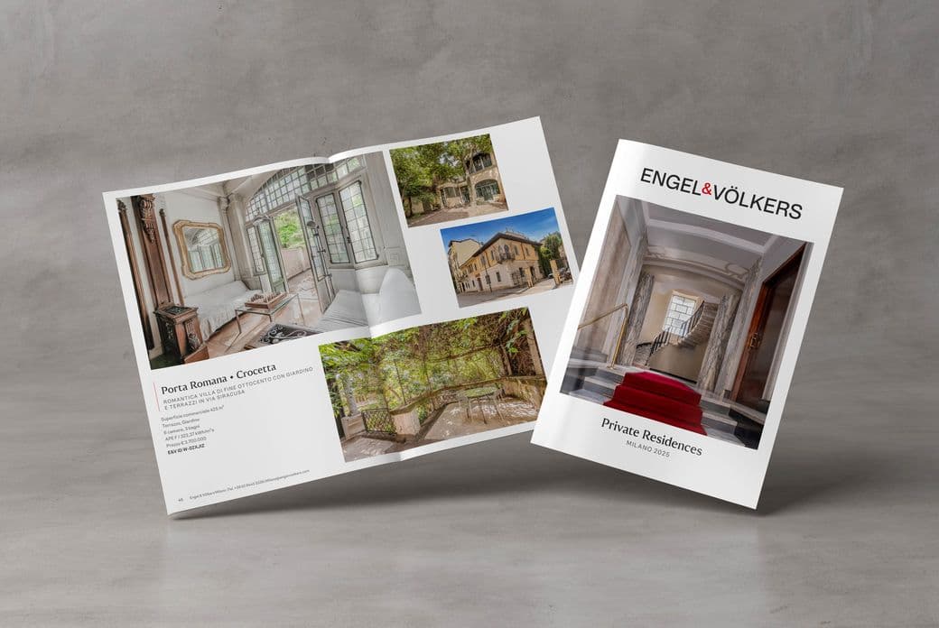 Copertina della pubblicazione Private Residence di Engel & Völkers con l’immagine di un elegante portone di un immobile nel centro di Milano e, accanto, la rivista aperta che mostra fotografie di interni di immobili milanesi di pregio.
