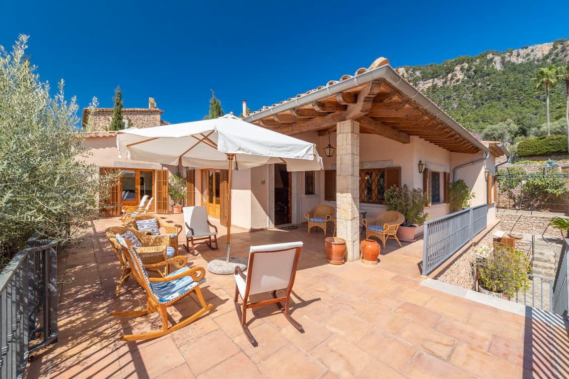 Terrace of a rustic countryside house in the mountains of Valldemossa, featuring traditional stonework and serene mountain views