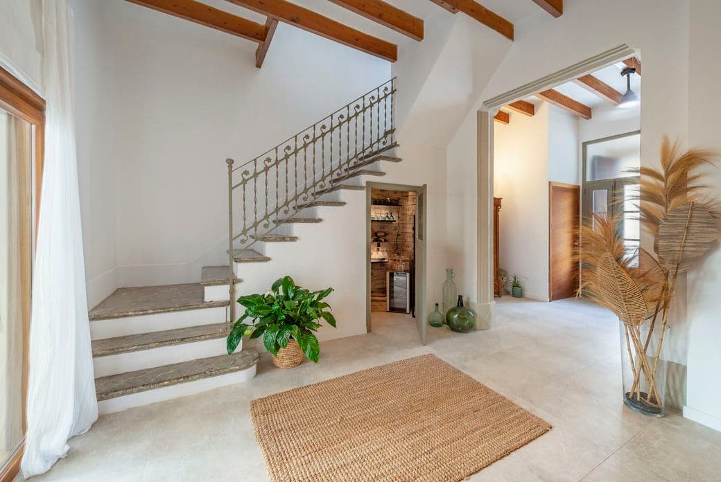 Encantadora casa adosada en Alcudia con una entrada acogedora, enmarcada por plantas mediterráneas y detalles arquitectónicos de estilo.