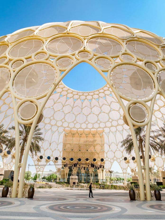 Expo City Dubai Al Wasl Plaza dome with golden lattice structure and open courtyard under blue sky