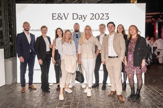 I dipendenti di Engel & Völkers davanti al muro dell'evento per l'E&V Day 2023