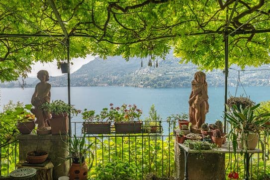 Begrünte Pergola mit Steinstatuen und Blick auf den Comer See in Blevio