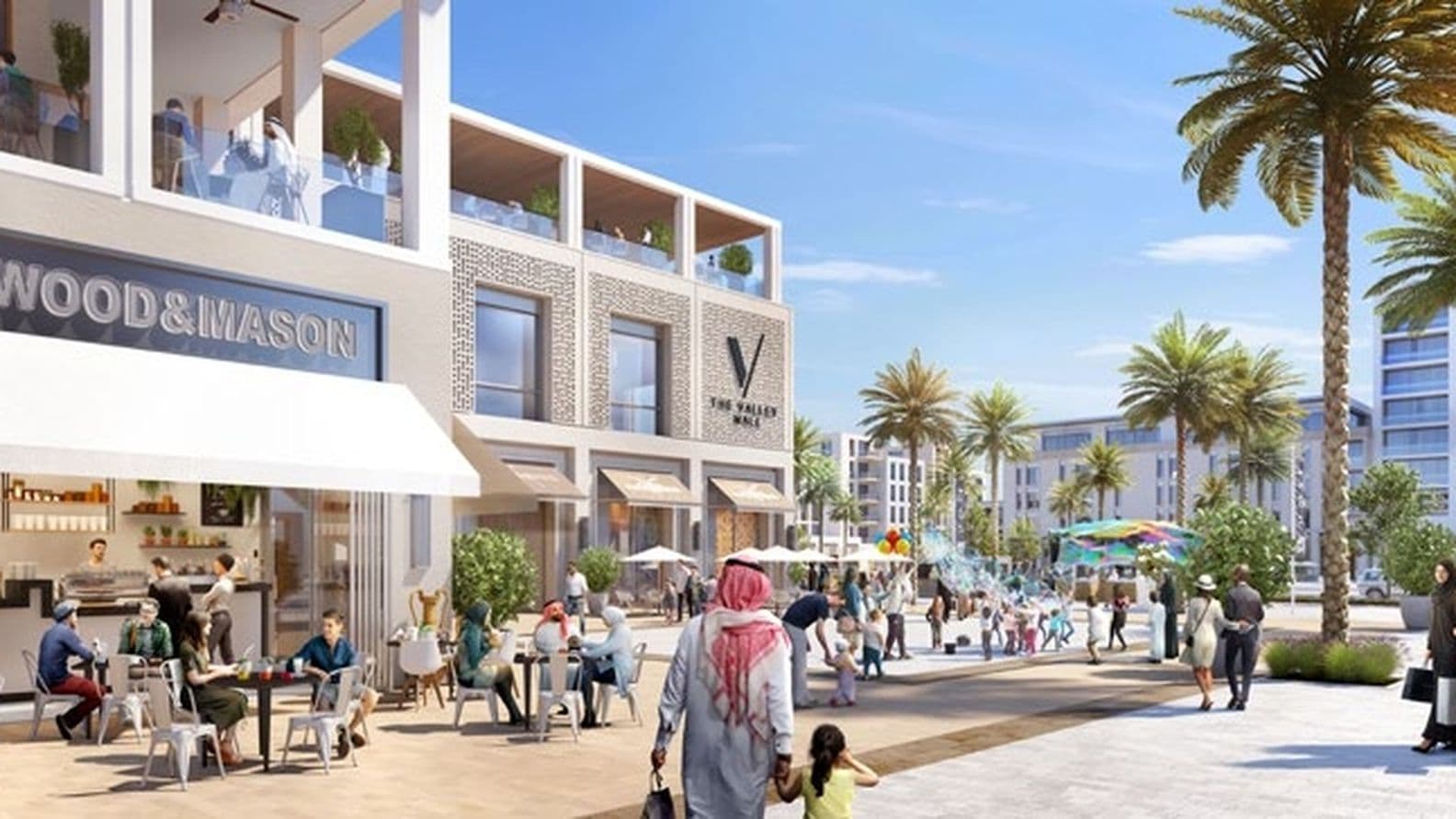 Outdoor cafe and shops with people walking and dining in a sunny plaza, lined with palm trees and modern buildings under a clear blue sky.