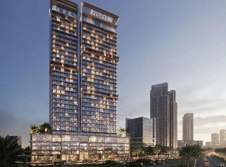 Exterior view of Voxa in Jumeirah Village Triangle showing the twin tower structure with glass façades, the Pantheon rooftop signage, and the multi level podium overlooking landscaped areas and surrounding high rise buildings.  If you want a shorter or even more minimal version for SEO, I can rewrite it.