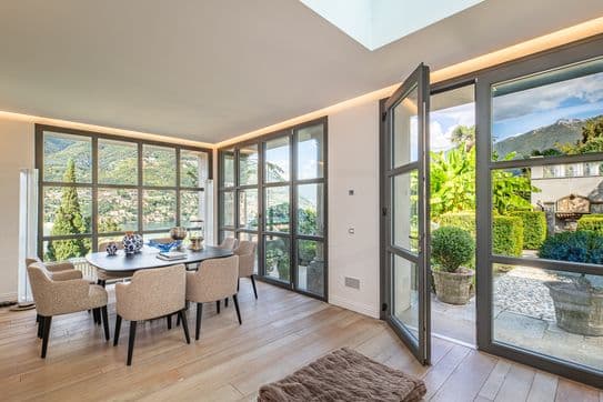 Lichtdurchflutetes Esszimmer mit großen Fenstern und Blick in den Garten