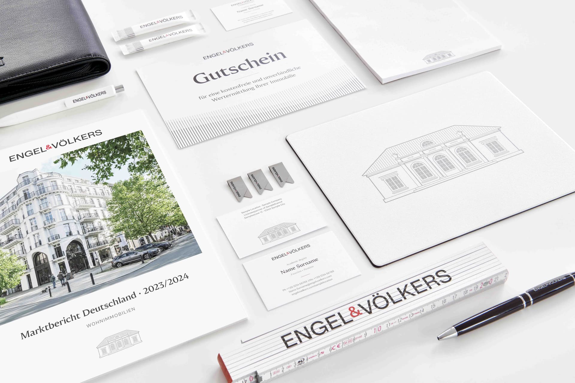Engel & Völkers branded stationery set, including brochures, cards, envelopes, and a pen, arranged neatly on a light surface.
