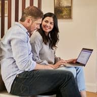 Una pareja viendo información en un portátil