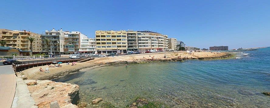 Cala del Palangre Torrevella, vista al mar i edificis.