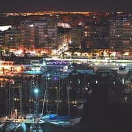 Vista nocturno del puerto en Torrevieja con barcos, y los edificios cerca el puerto