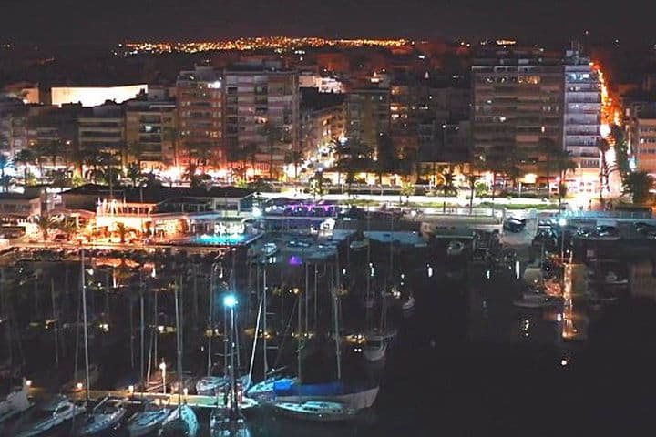 Night view of the port in Torrevieja with boats and the buildings near the port.
