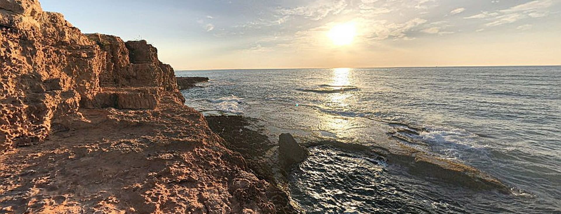 Vista de la Cala Tía Roqueta Torrevieja por el amanecer con el mar y rocas