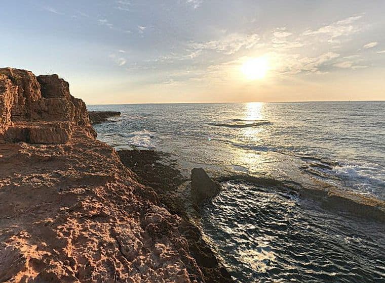 Vista de la Cala Tia Roqueta Torrevella a l'albada amb el mar i les roques.