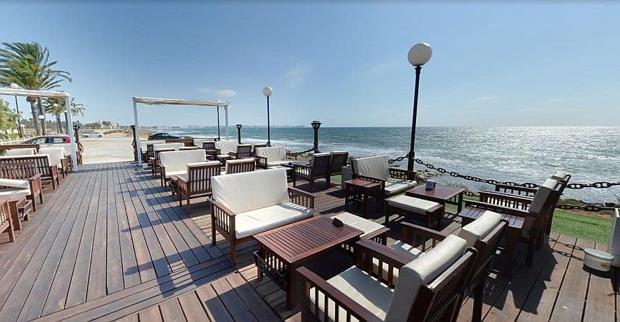 Imatge d'un restaurant de primera línia buit a Punta Prima mirant cap a Torrevella.