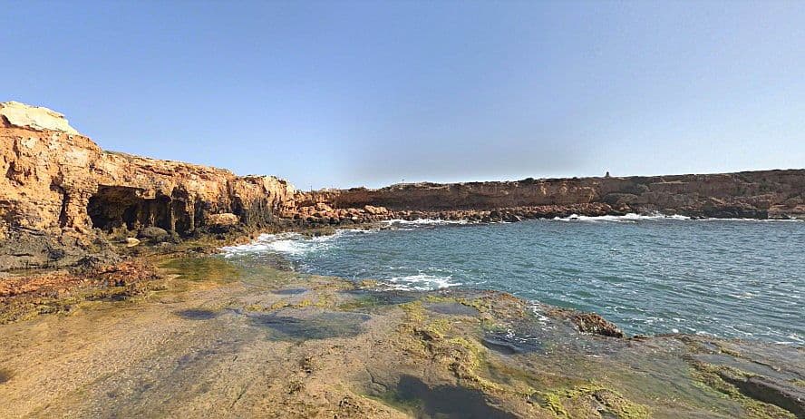 Cala Cornuda Torrevella, vista de la cala amb roques i el mar.