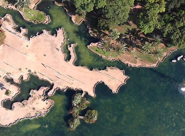 Vista panoràmica d'un parc a Torrevella amb arbres, aigua i parcel·les de terra.