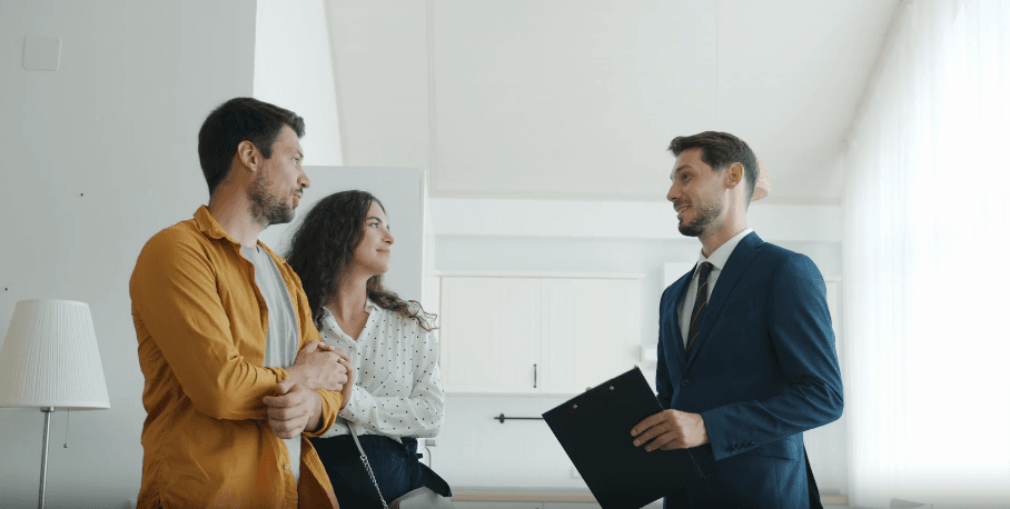 agente inmobiliario enseñando una casa a una pareja