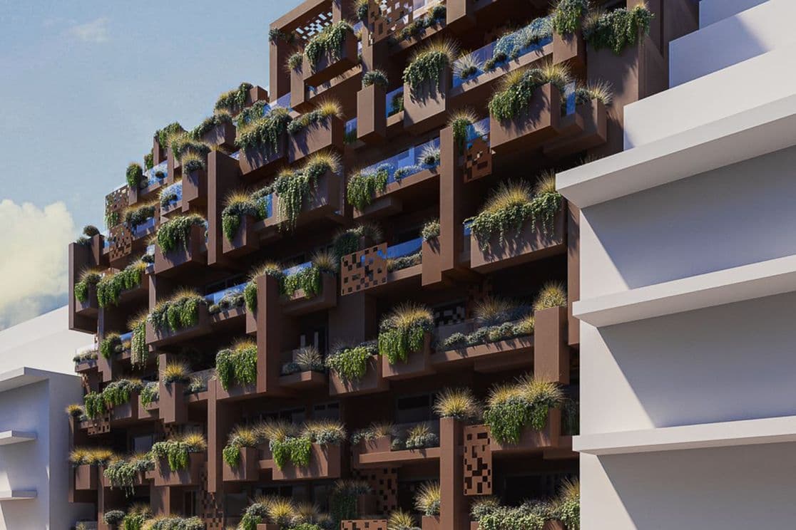 Brown modular building with stacked perforated boxes and abundant plants cascading from balconies, under a clear blue sky.