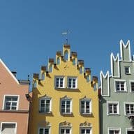 View of the upper floors of three colorful apartment buildings