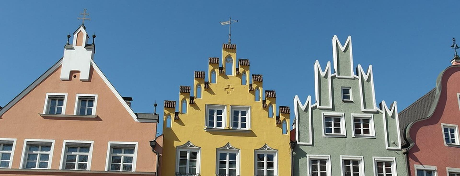 View of the upper floors of three colorful apartment buildings