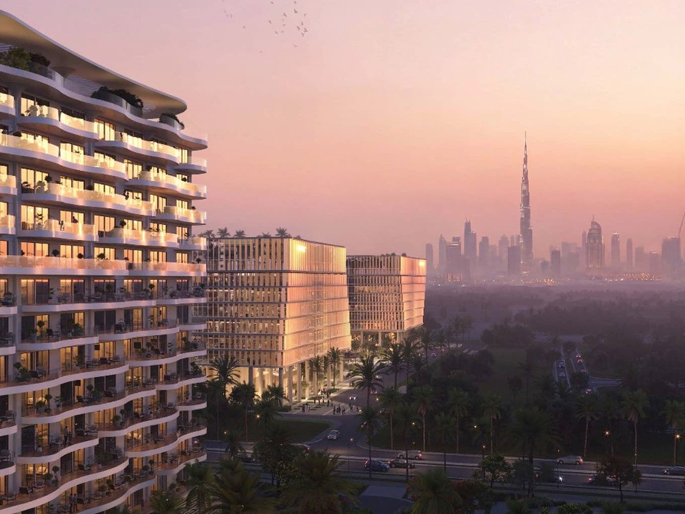 Sunset view of a curved glass-fronted residential tower with balconies, palm-lined streets, and a distant skyline topped by a tall spire.