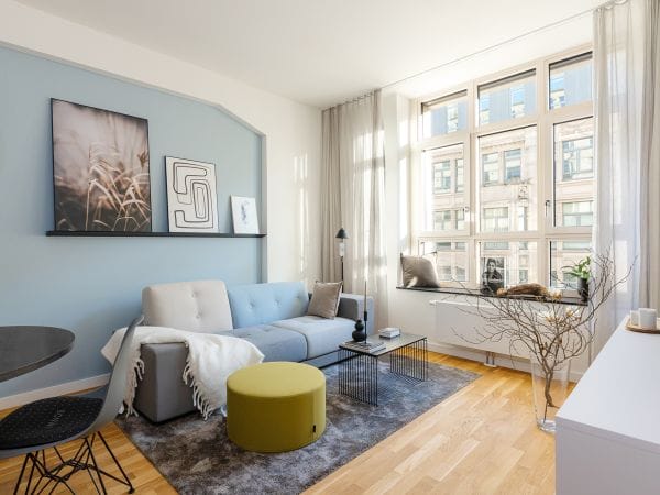 Living room with modern furniture, a blue wall and grey decor