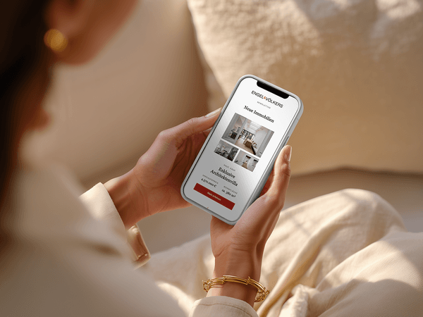 Person holding a smartphone displaying a real estate app with house listings and a button labeled "See All Photos."