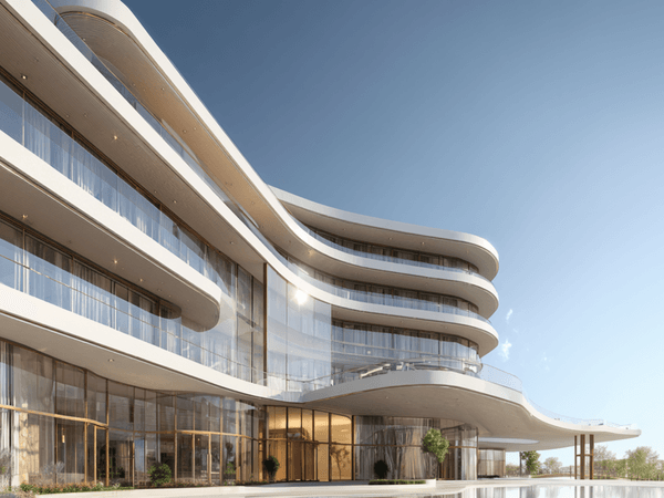 Modern, curvilinear building with large glass windows and balconies, set against a clear blue sky.